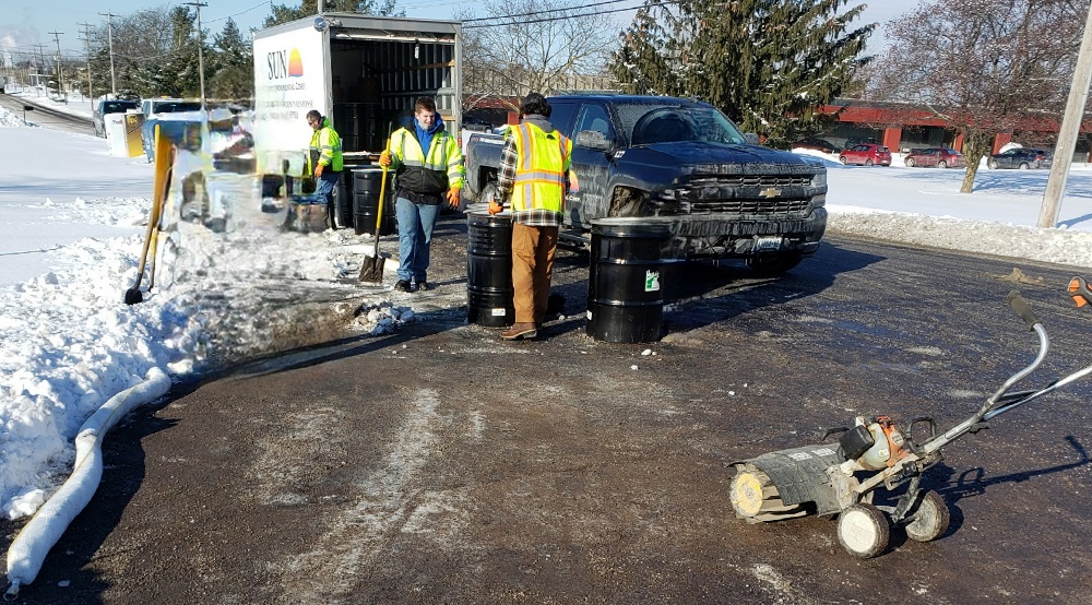 Workers containing hazardous materials in drums