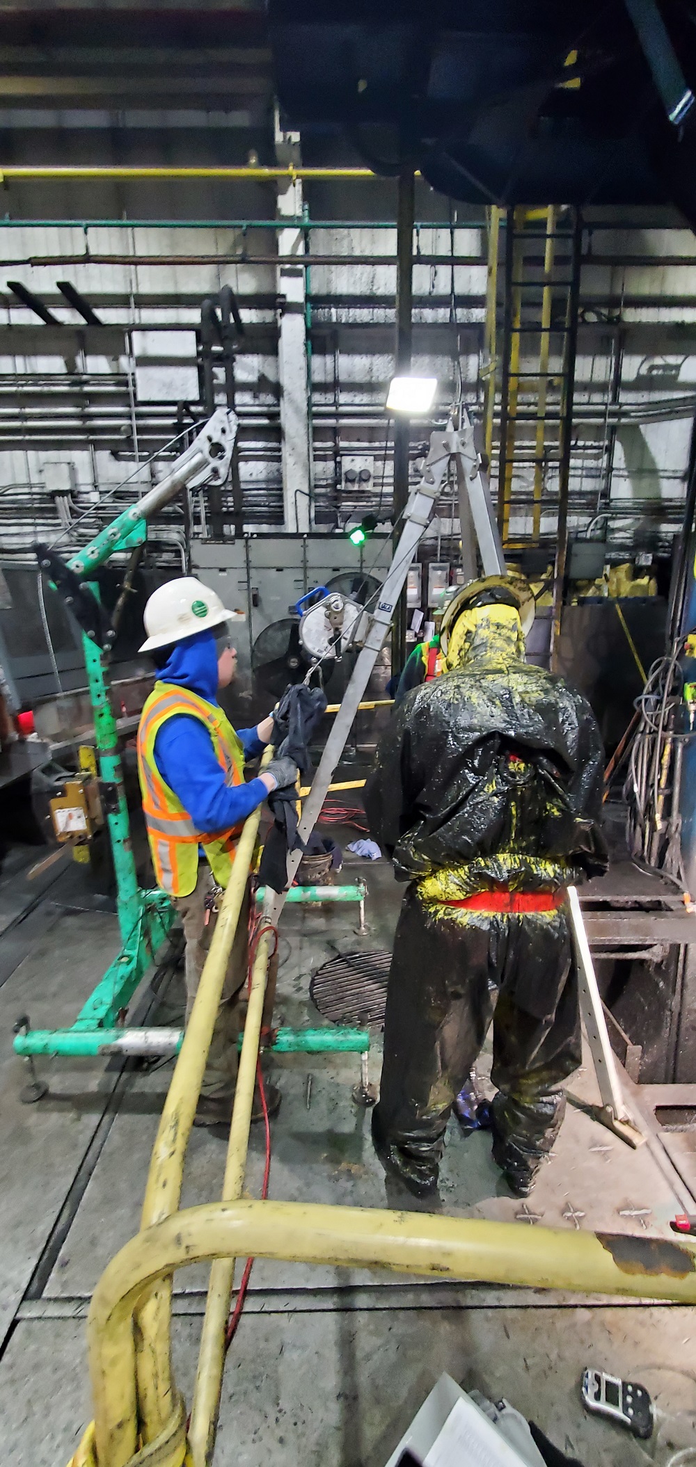 Worker in protective gear preparing to enter confined space