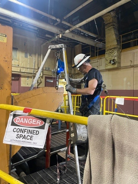 Maintenance worker preparing to enter confined space