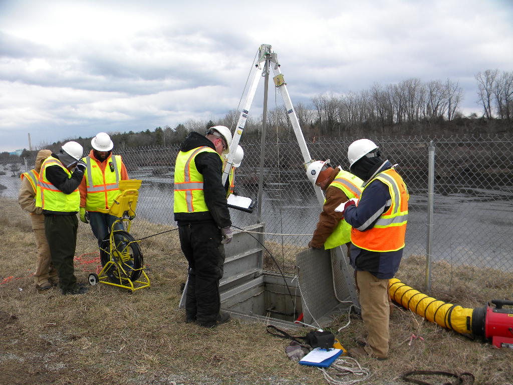 Maintenance workers setting up equipment at confined entry