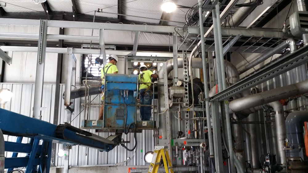 Workers inside building on machinery
