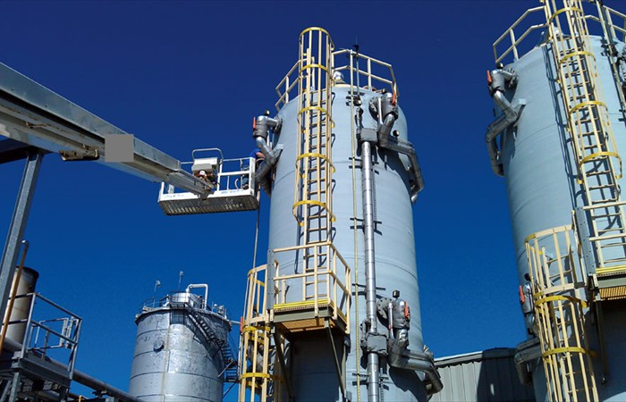Team cleaning industrial silos outside