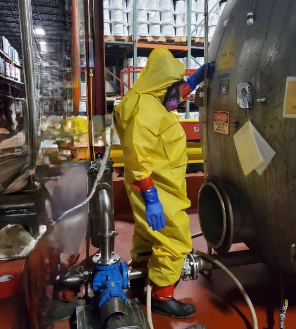 Worker inspecting storage tank for defects