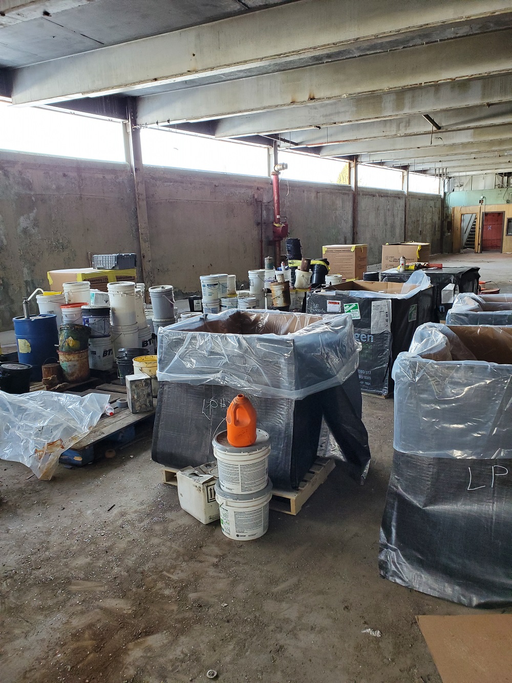 Waste in buckets and drums in preparation for removal